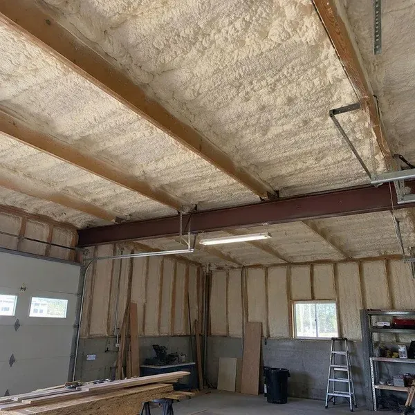 Thermal acoustic spray covering an exposed workshop ceiling
