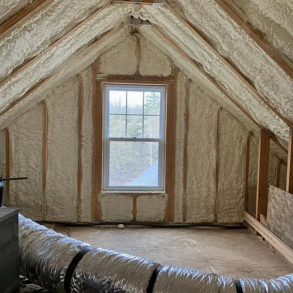 Finished attic spray foam insulation around a small gable window