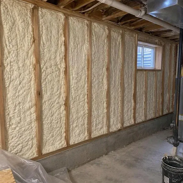 Spray foam insulation between basement wall studs