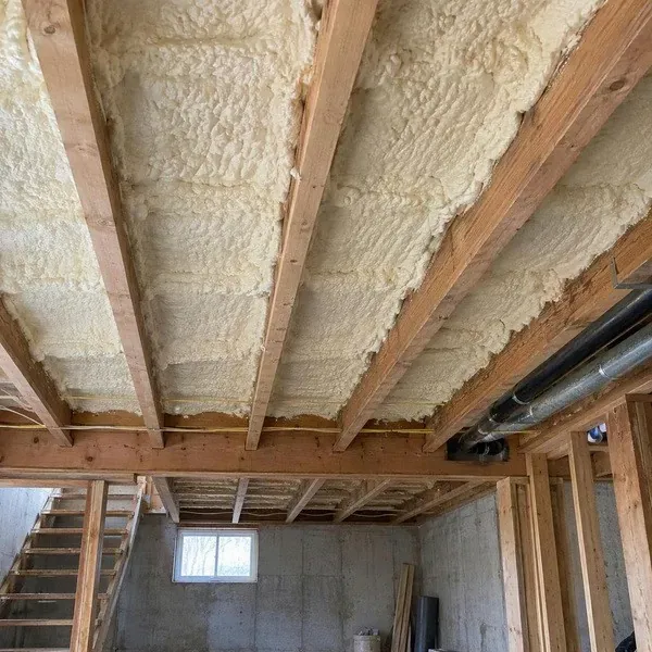 Spray foam insulating the floor cavity above an unfinished room