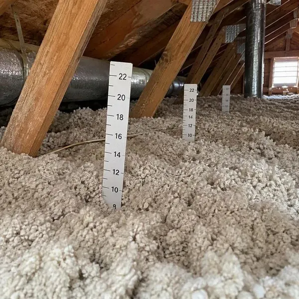 Attic depth rulers marking blown-in insulation depth for an R-60 top-up