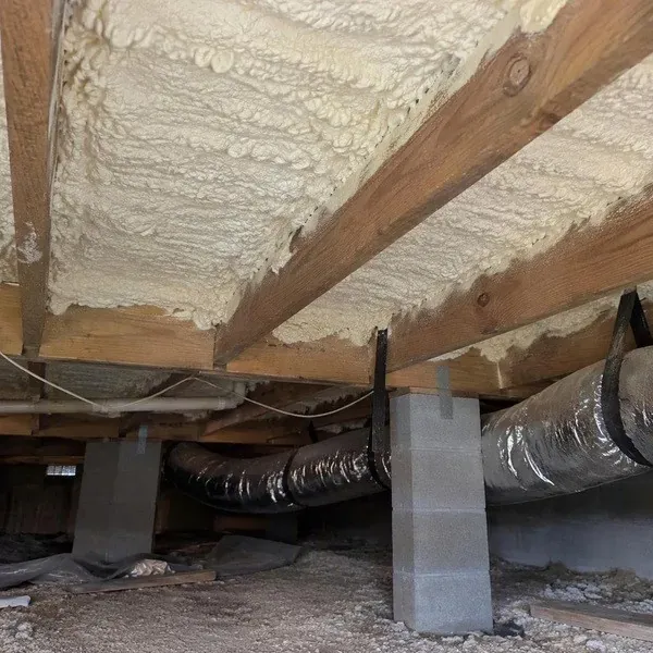 Spray foam between floor joists above a crawl space