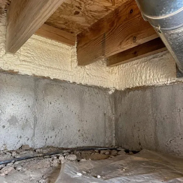 Spray foam sealing the rim joist corner of a crawl space