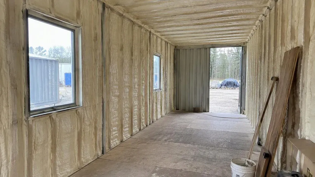 Converted shipping container fully insulated with closed cell spray foam