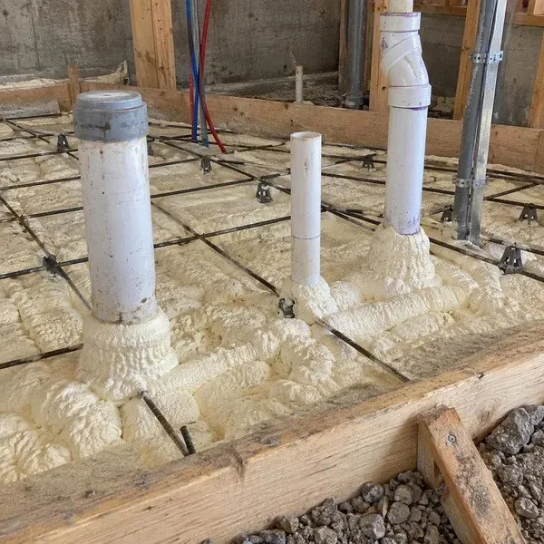 Underslab spray foam sealed around plumbing risers